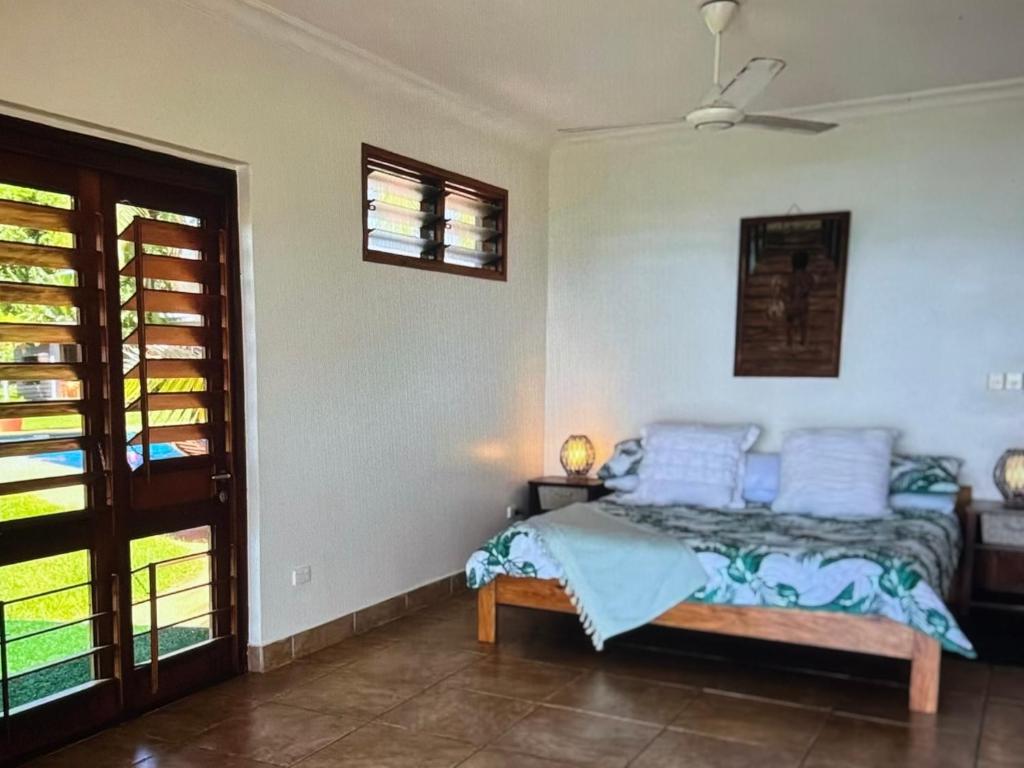 a bedroom with a bed with blue pillows at Amazing view in Port Vila