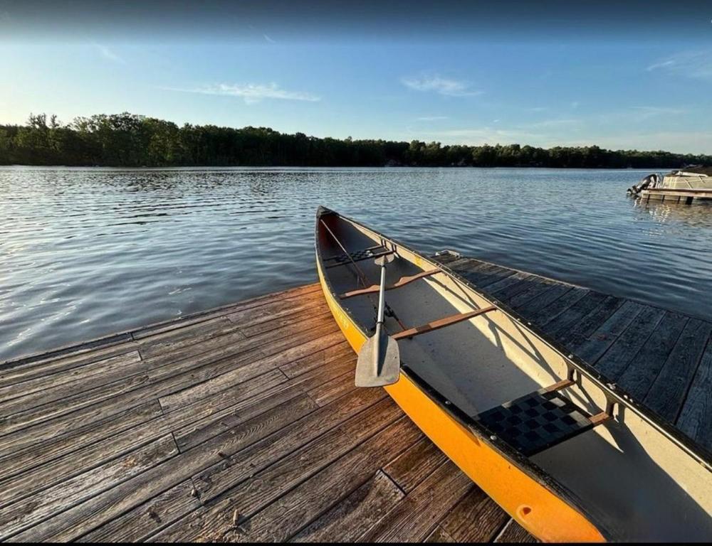 a canoe sitting on a dock on a lake at Lake Front Sunset | New Deck | Kayaks | Canoe in Salisbury