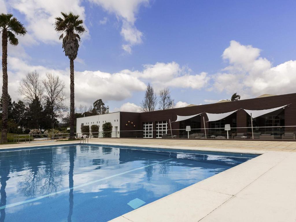 a large swimming pool in front of a building at Novotel Setubal in Setúbal