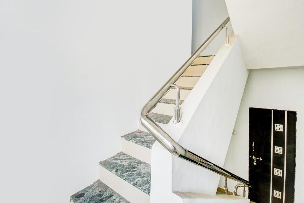 eine Treppe mit einer Metallgriffe und Marmortreppen in der Unterkunft Hotel O Happy Stay in Méribel Village