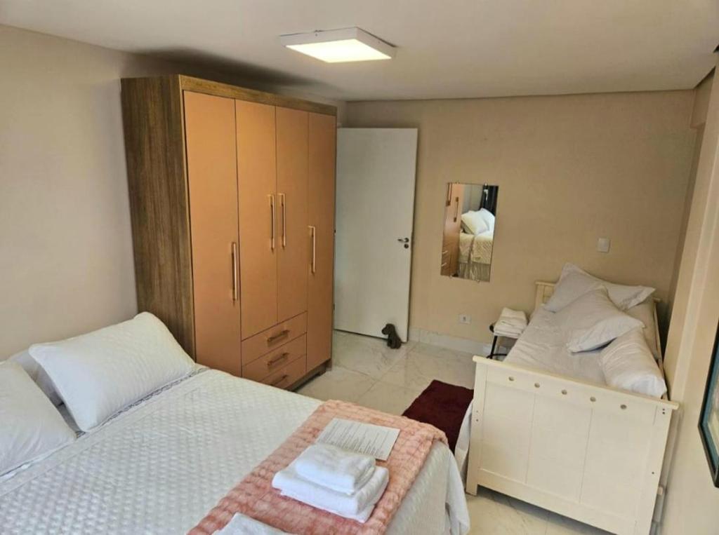 a bedroom with two twin beds and a closet at Apartamento Central in Cascavel