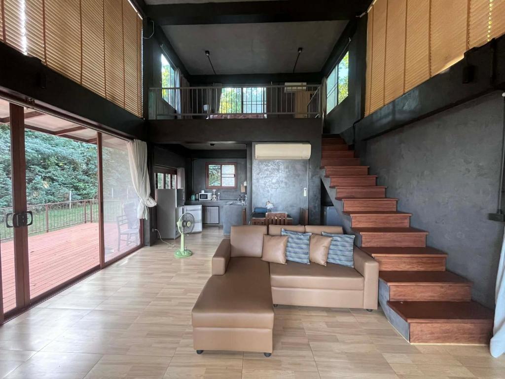 een woonkamer met een bank en een trap bij The Hill Koh Mak 