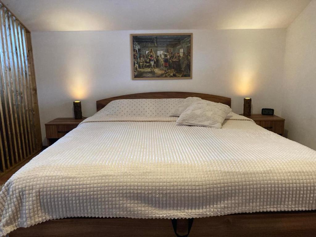 ein Schlafzimmer mit einem großen Bett mit einer weißen Bettdecke in der Unterkunft Студио за гости Петрови in Bansko