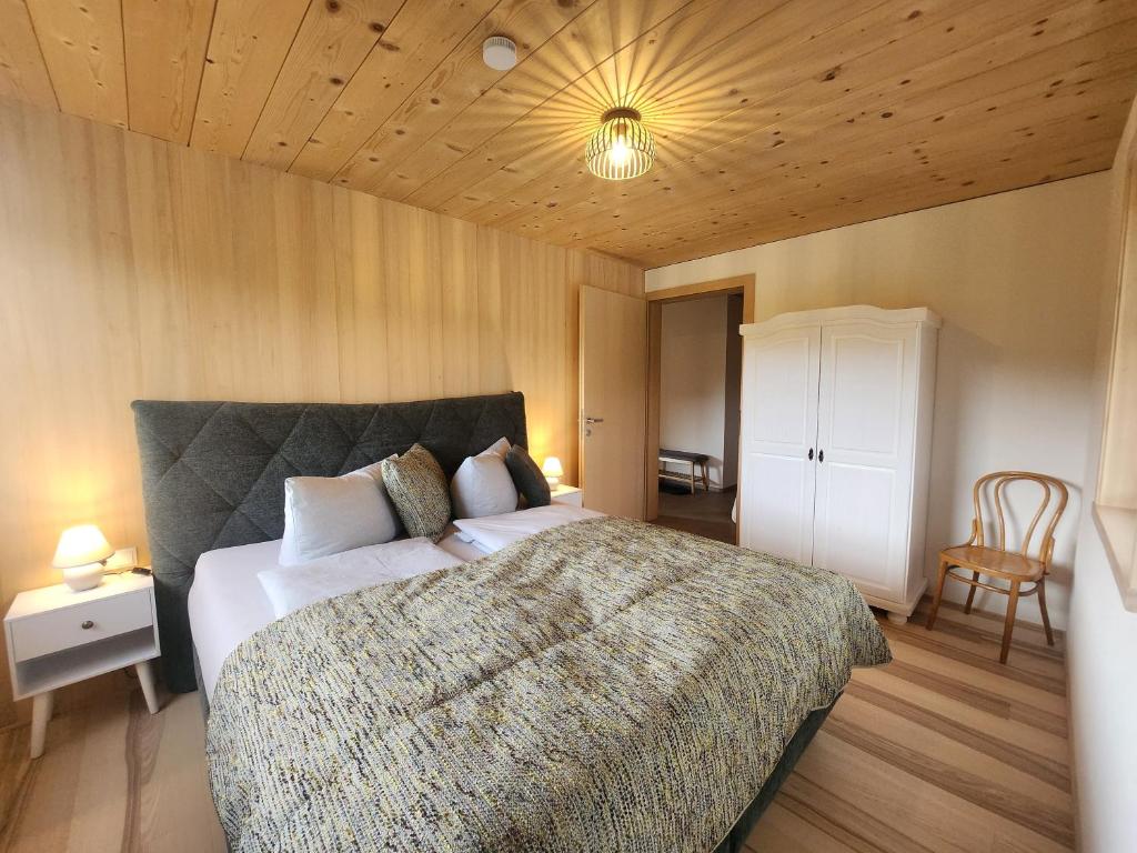 una camera da letto con un letto grande e un soffitto in legno di Blickfang Bregenzerwald a Langenegg