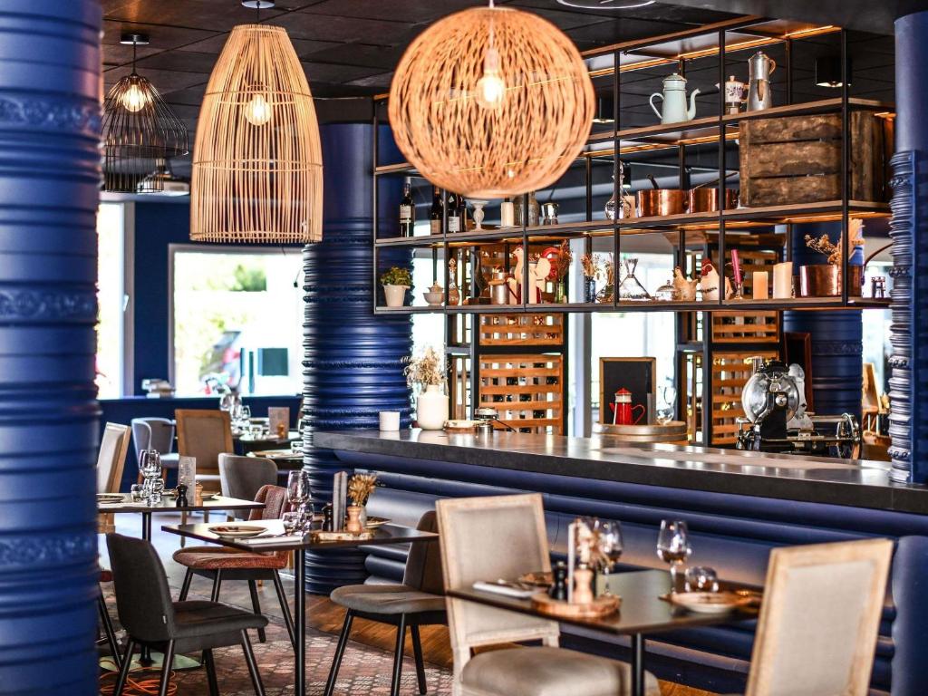 een restaurant met tafels en stoelen en een bar bij Hotel Mercure Château de Fontainebleau in Fontainebleau