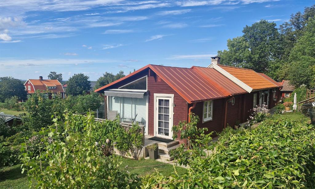 een klein huis met een oranje dak op een heuvel bij Unikt sommarboende in Färjestaden