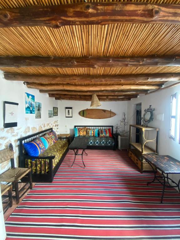 a living room with couches and a rug at Studio Surf House Kaouki in Sidi Kaouki