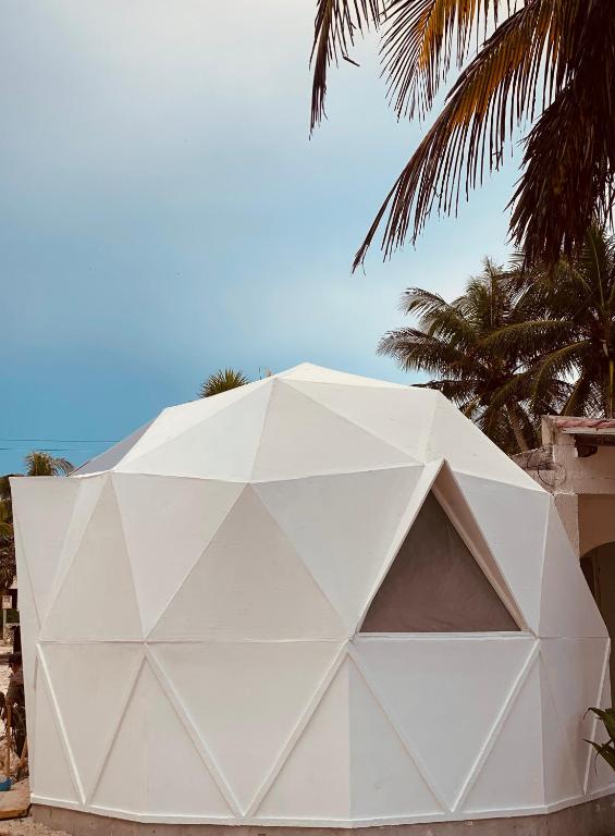 a large white tent with palm trees in the background at Frequency Beachfront Domes El Cuyo in El Cuyo