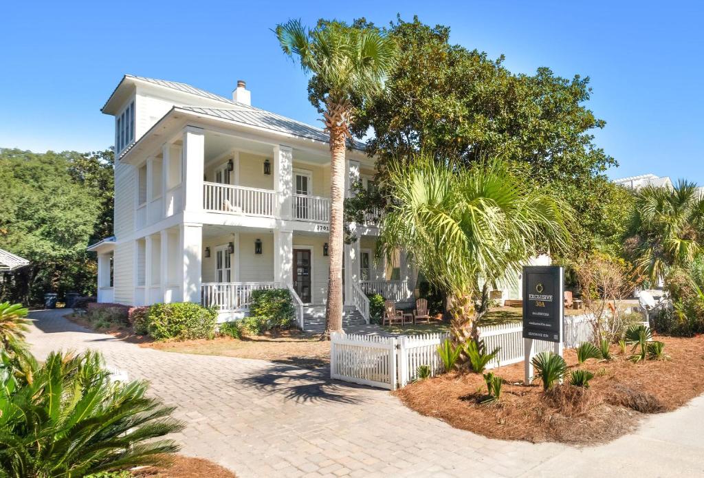 a white house with palm trees in front of it at Seagrove Sun in Santa Rosa Beach