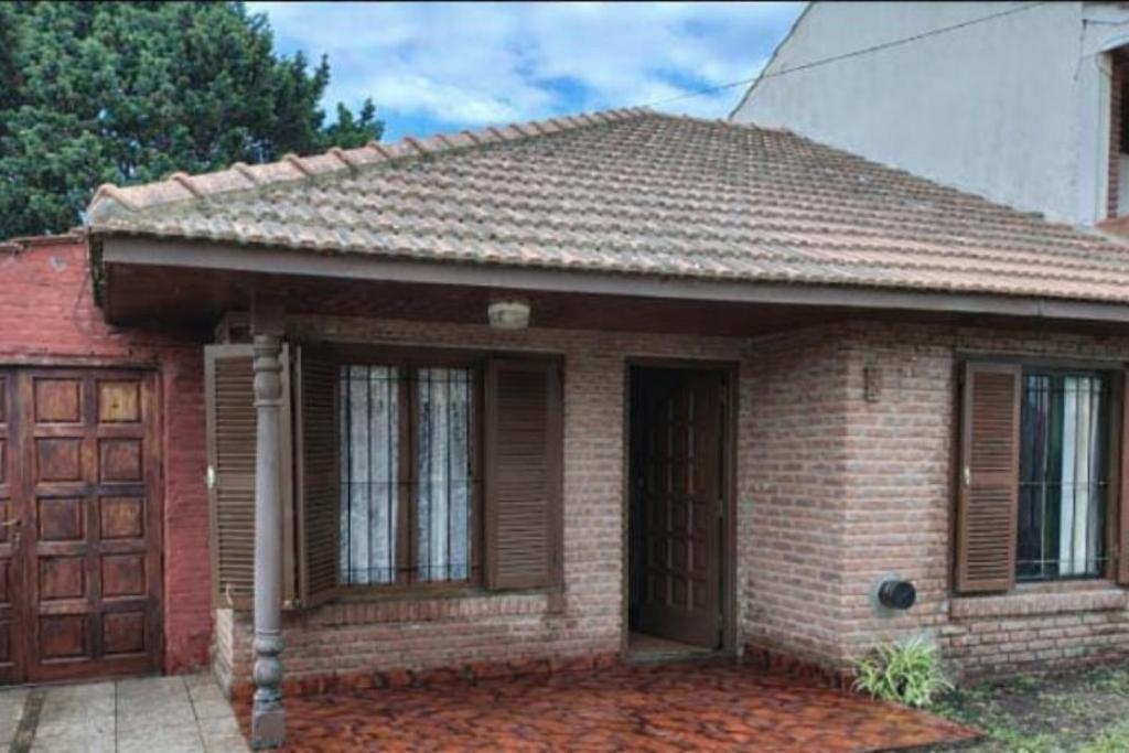 una piccola casa in mattoni con porta in legno di Casa Alina a Santa Clara del Mar