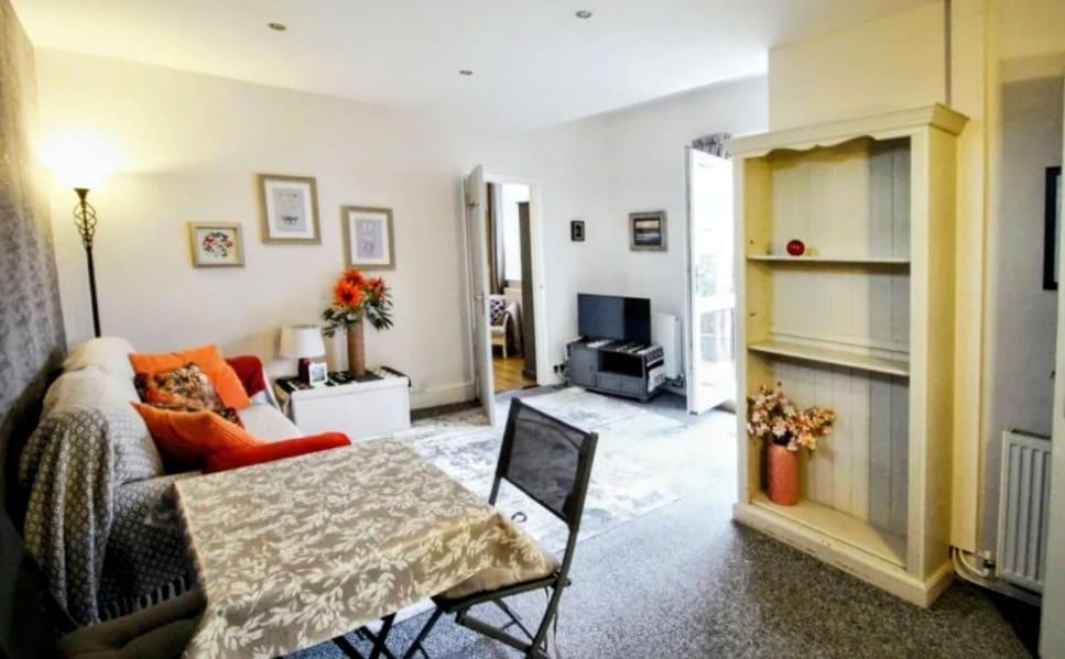 un salon avec un canapé et une table dans l'établissement Seaford Snug, à Seaford