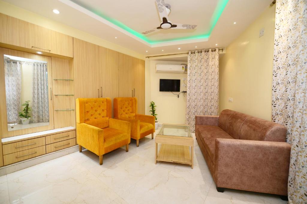 a living room with a couch and two chairs at Airport residency hotel ranchi in Arambol
