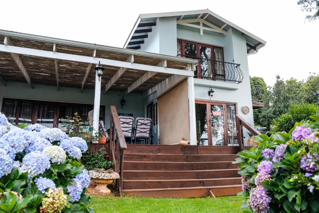 a house with flowers in front of it at Art Gallery Guest House in Haenertsburg