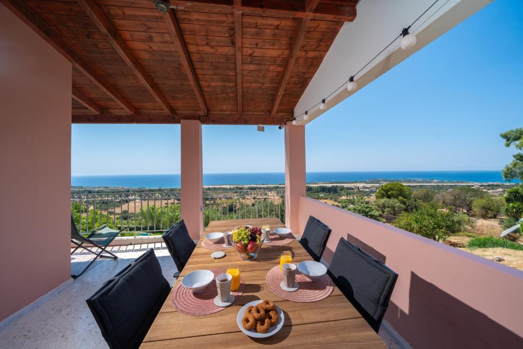 einen Esstisch auf dem Balkon eines Hauses in der Unterkunft Thea Sea View Kefalonia in Sarláta