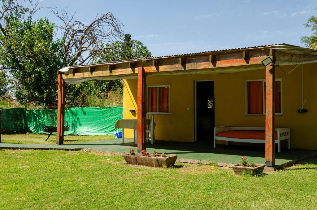 een klein geel huisje met een bed in een tuin bij Quinta El Oasis in Junín