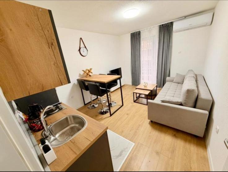 a kitchen and living room with a couch and a table at Apartman Maras in Posušje