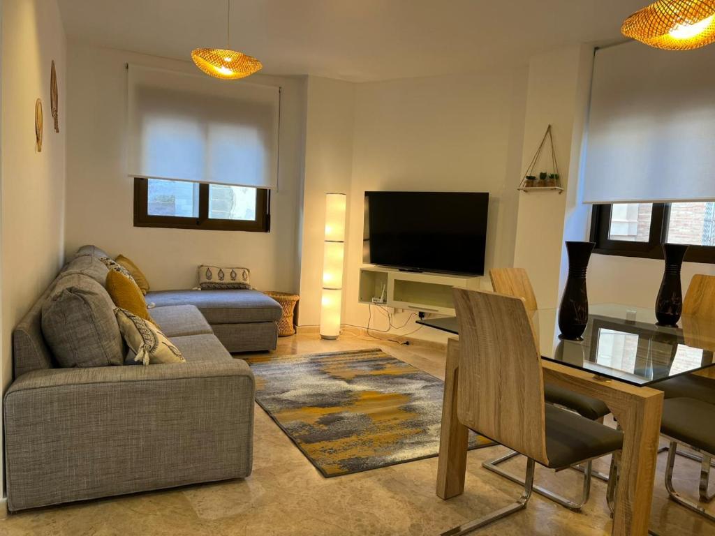 een woonkamer met een bank, een tafel en een televisie bij La Llum de Serra in Serra