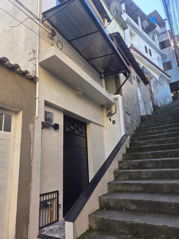 een trap die leidt naar een zwarte deur op een gebouw bij Sua Estadia Angra in Angra dos Reis