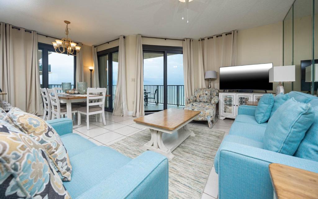 a living room with a blue couch and a table at Phoenix East 1211 in Orange Beach