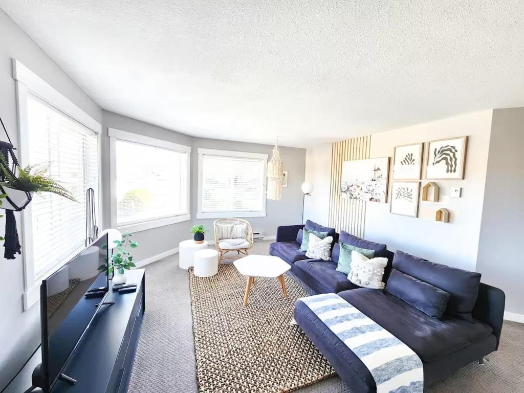 ein Wohnzimmer mit Sofa und Tisch in der Unterkunft Modern Lake City Getaway in Penticton