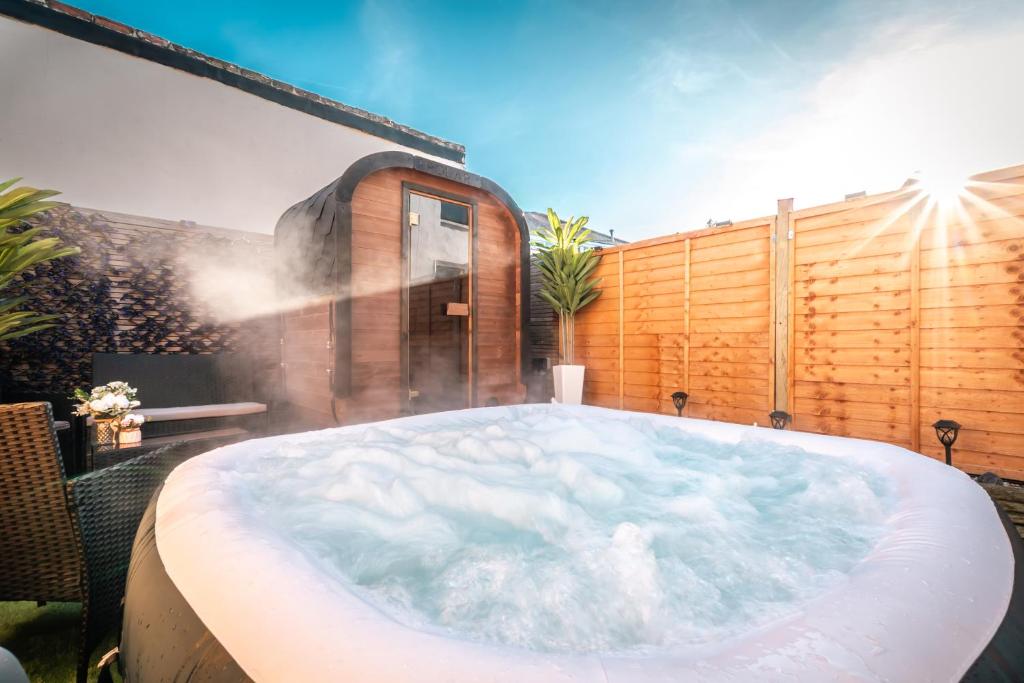 een jacuzzi in een achtertuin met een hek bij Hot Tub & Sauna Retreat , 4BR with Free Parking in Portsmouth