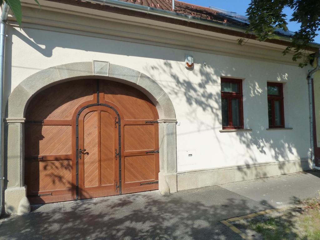 a garage with a wooden door on a house at Kabóca Vendégház in Vác