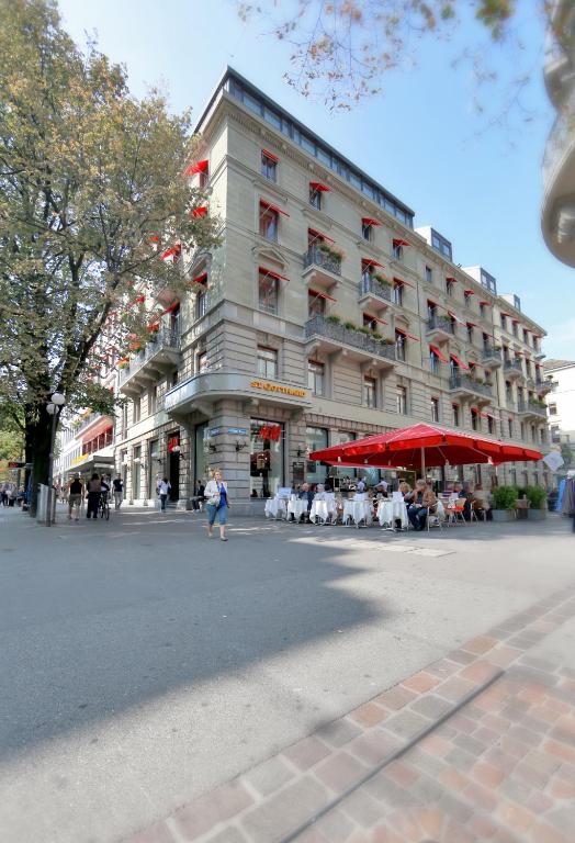 a large building with tables and chairs in front of it at Hotel St.Gotthard in Zürich