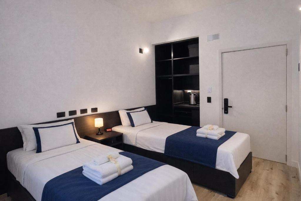 a hotel room with two beds with towels on them at BA Millenium in Buenos Aires