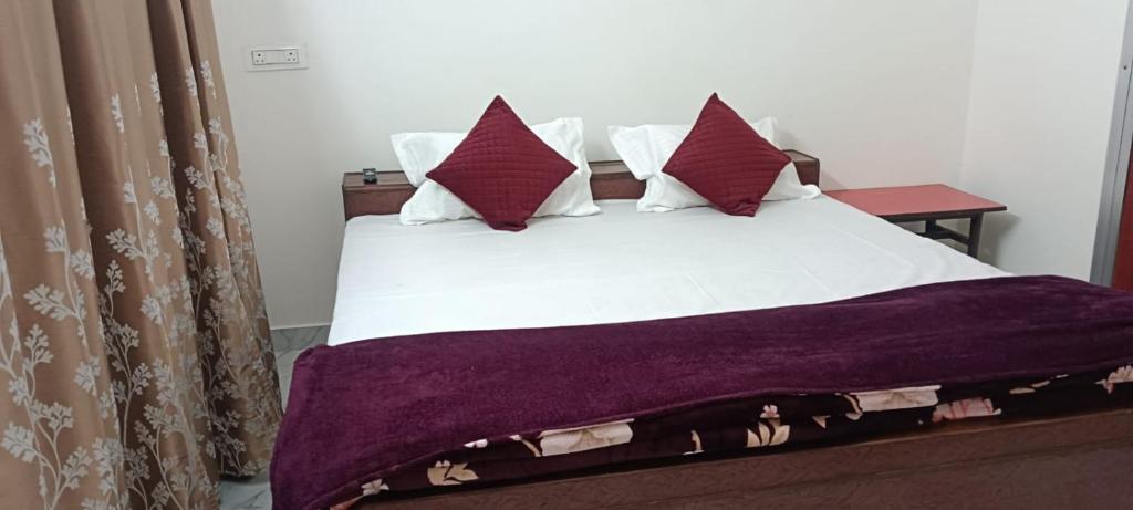 a bedroom with a bed with white sheets and pillows at श्रीजीर Kunj in Varanasi