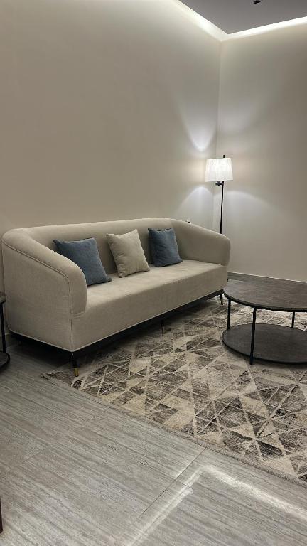 een woonkamer met een bank en een tafel bij شقه بصالة وغرفتين نوم in Hafr Al Baten
