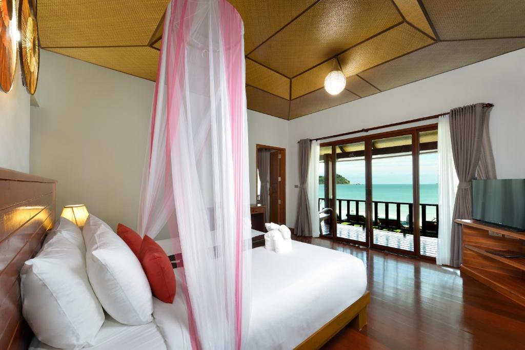 a bedroom with a bed and a view of the ocean at PingChan Koh Phangan Beachfront Resort in Thong Nai Pan Yai