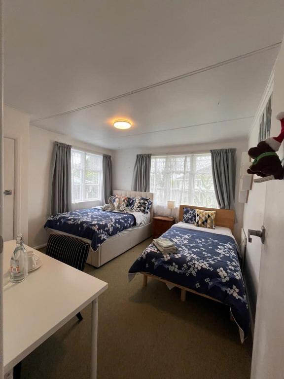 a bedroom with two beds and a table in it at Cosy Corner in Hamilton
