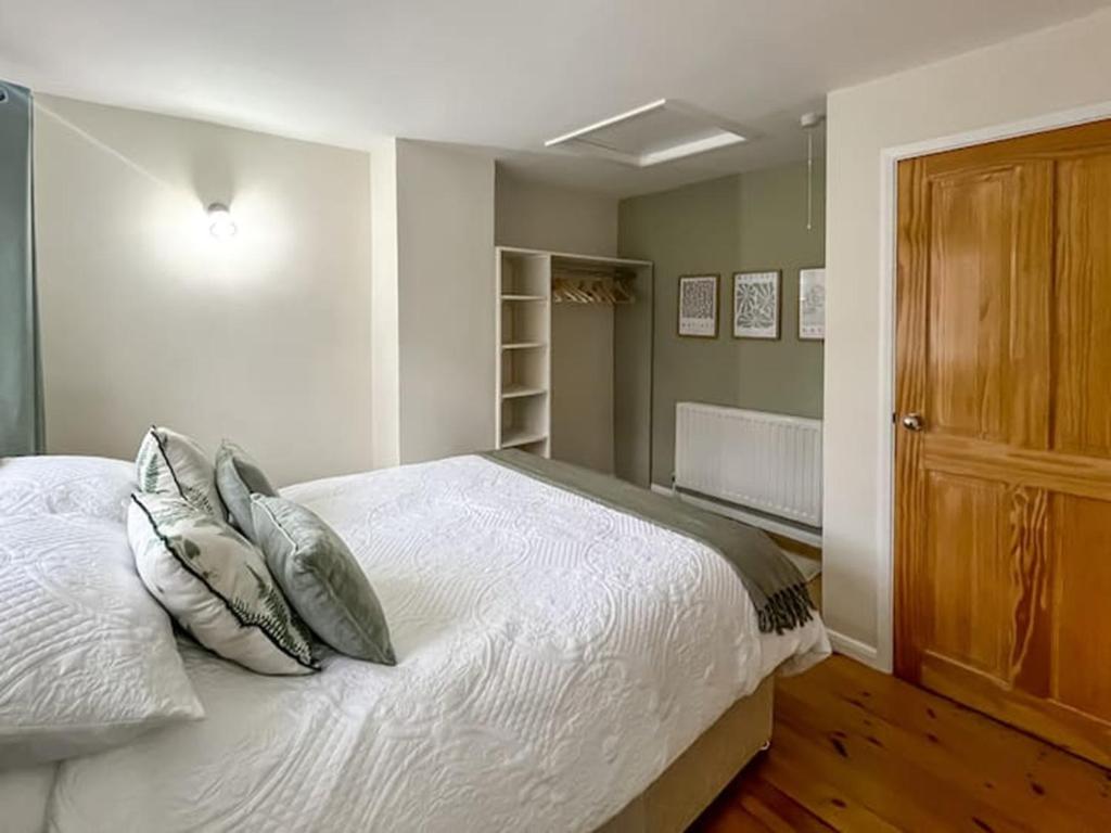 a bedroom with a large white bed with pillows at Tap Cottage in Burgh le Marsh