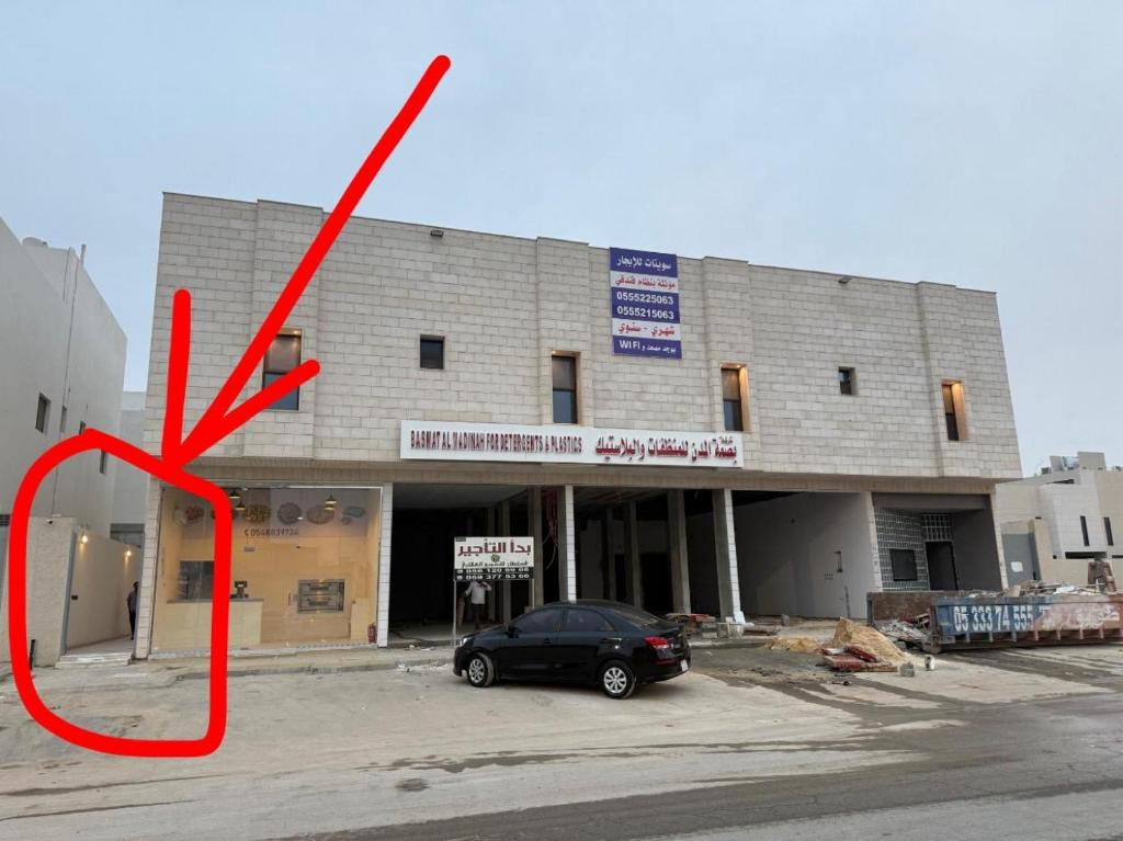 een auto geparkeerd op een parkeerplaats voor een gebouw bij Supreme suites in Al Kharj