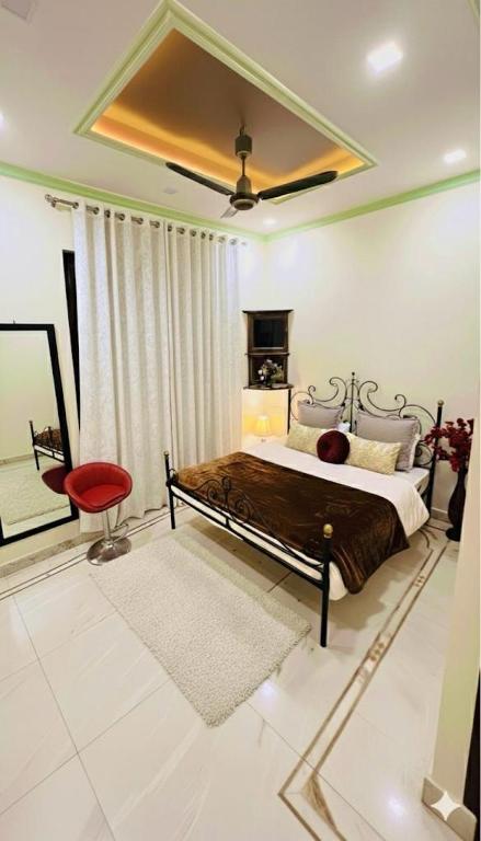 ein Schlafzimmer mit einem Bett und einem roten Stuhl in der Unterkunft Krishna kunj in Varanasi