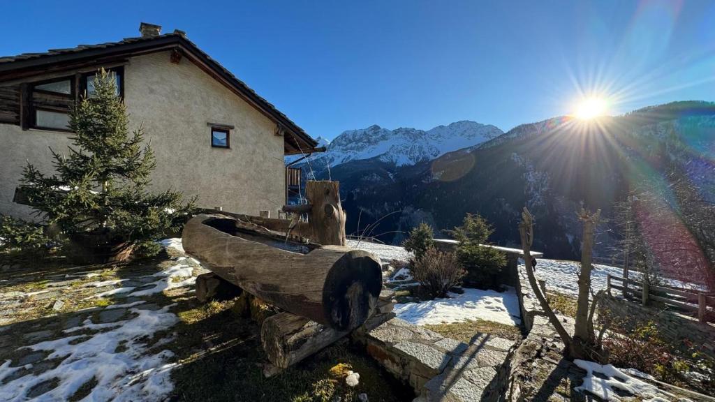 una panchina di legno di fronte a una casa nella neve di BARDONECCHIA SCI E RELAX a Bardonecchia