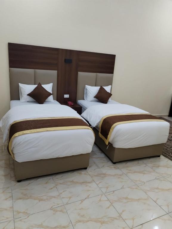 two beds sitting next to each other in a room at شقة مفروشة حائل in Hail