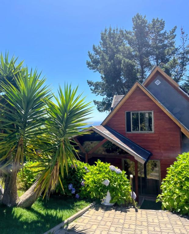 a house with palm trees in front of it at Casa en Pingueral para 7 personas in Dichato
