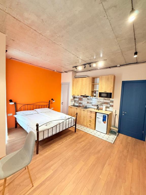 a bedroom with a bed and an orange wall at Cosy City-View Flat in Mtatsminda, flat 7 in Itʼkhvisi