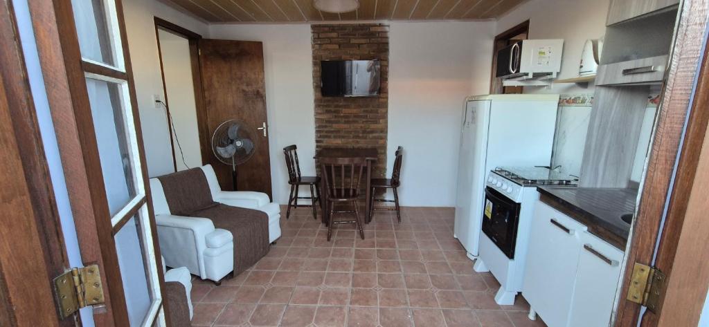 a kitchen with a white refrigerator and a table and chairs at Apartmento 3 in Santa Vitória do Palmar