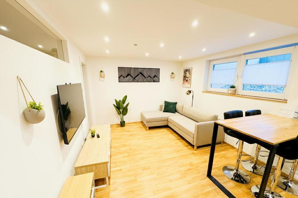 ein Wohnzimmer mit Sofa und Tisch in der Unterkunft 1,5-Zimmer, Top ausgestattet, 4 Pers, Souterrain, Self Check-in, Parkplatz, Netflix & Amazon Prime in Flintsbach