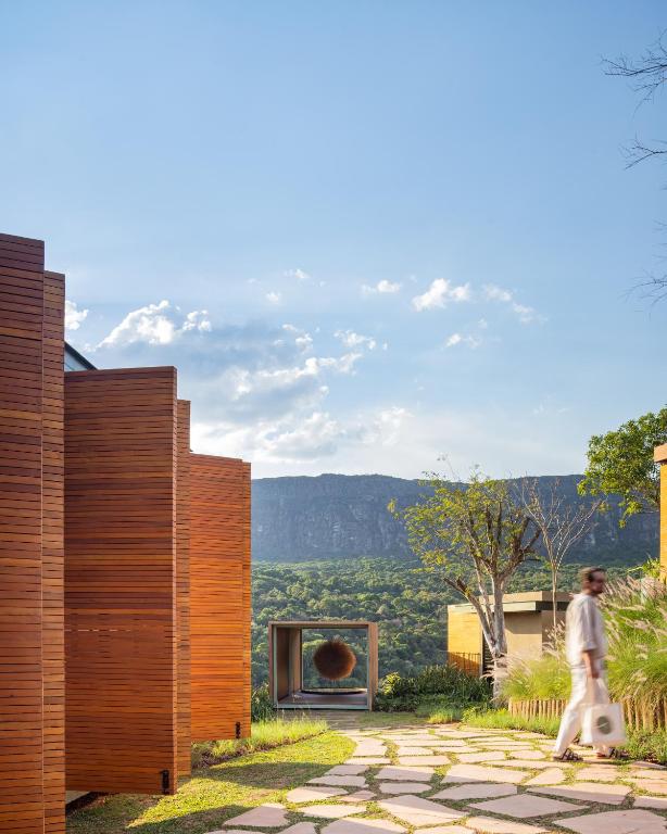 a woman walking down a stone path between two buildings at Bowi Hotel Conceito in Tiradentes