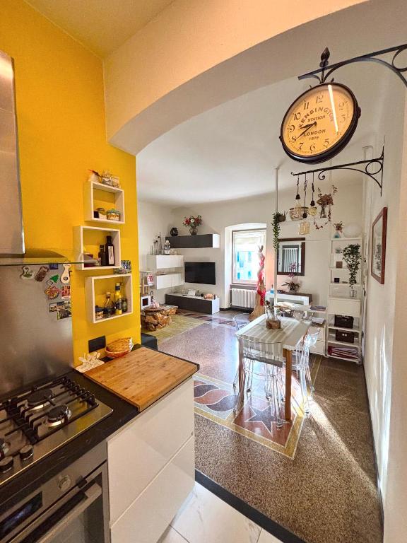 a kitchen with a table and a clock on the wall at Casa di Olli in Sestri Levante