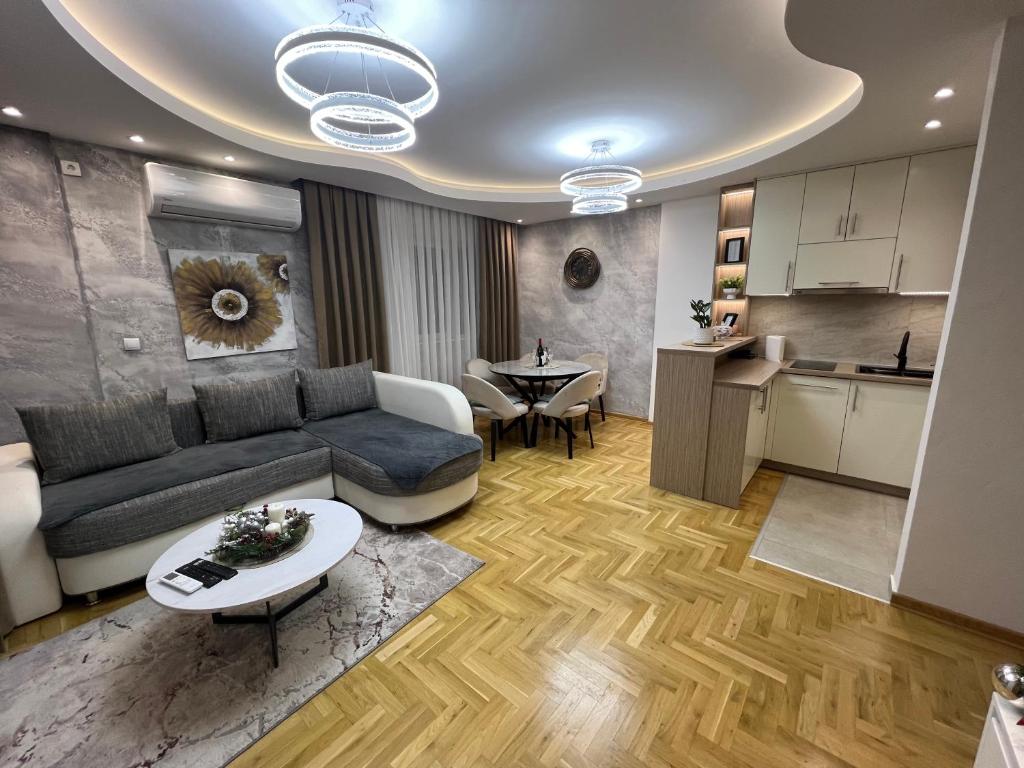 a living room with a couch and a table and a kitchen at Apartman Lux Jocić in Vrnjačka Banja