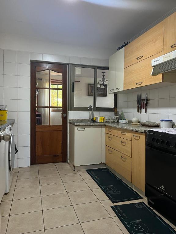 een keuken met houten kasten en een zwarte kachel bij Pingueral in Dichato