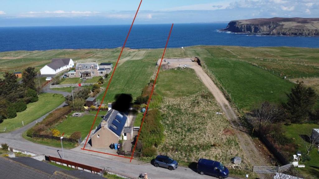 - une vue aérienne sur une maison et l'océan dans l'établissement Traditional 2 bed croft, à Portskerra