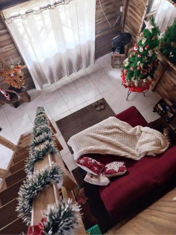 een woonkamer met kerstbomen en een bed bij Casa Rústica em Garopaba in Garopaba