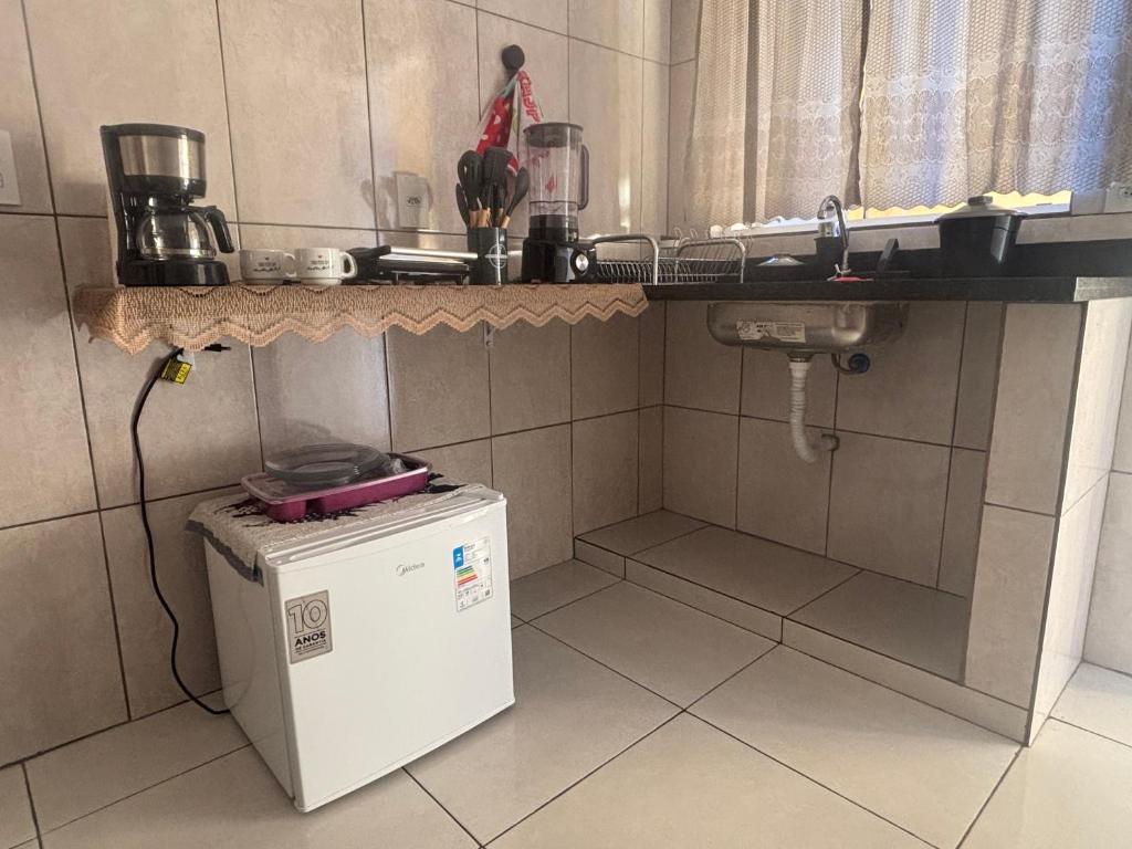 a small kitchen with a sink and a refrigerator at Casa Central in Serra Negra