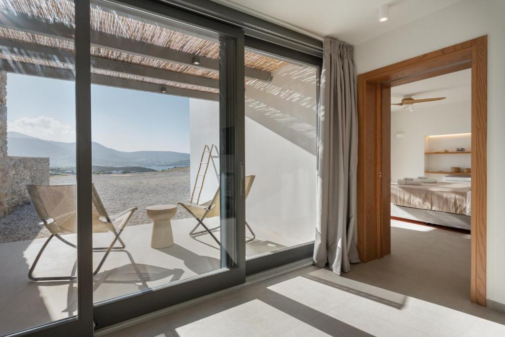 een kamer met glazen schuifdeuren en een slaapkamer bij Avera Villas in Parikia