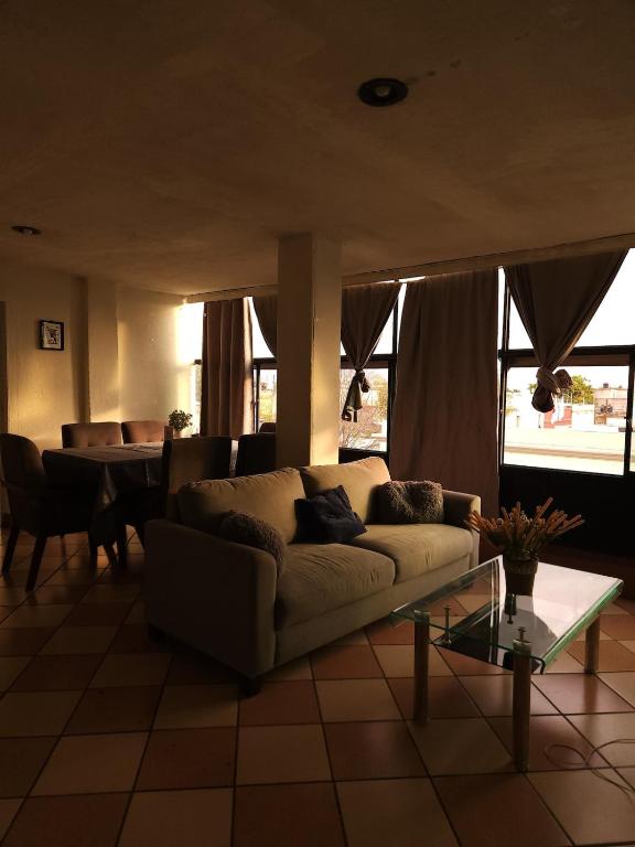 een woonkamer met een bank en een tafel bij Entire Space in Downtown Oaxaca Comfortable in Oaxaca City